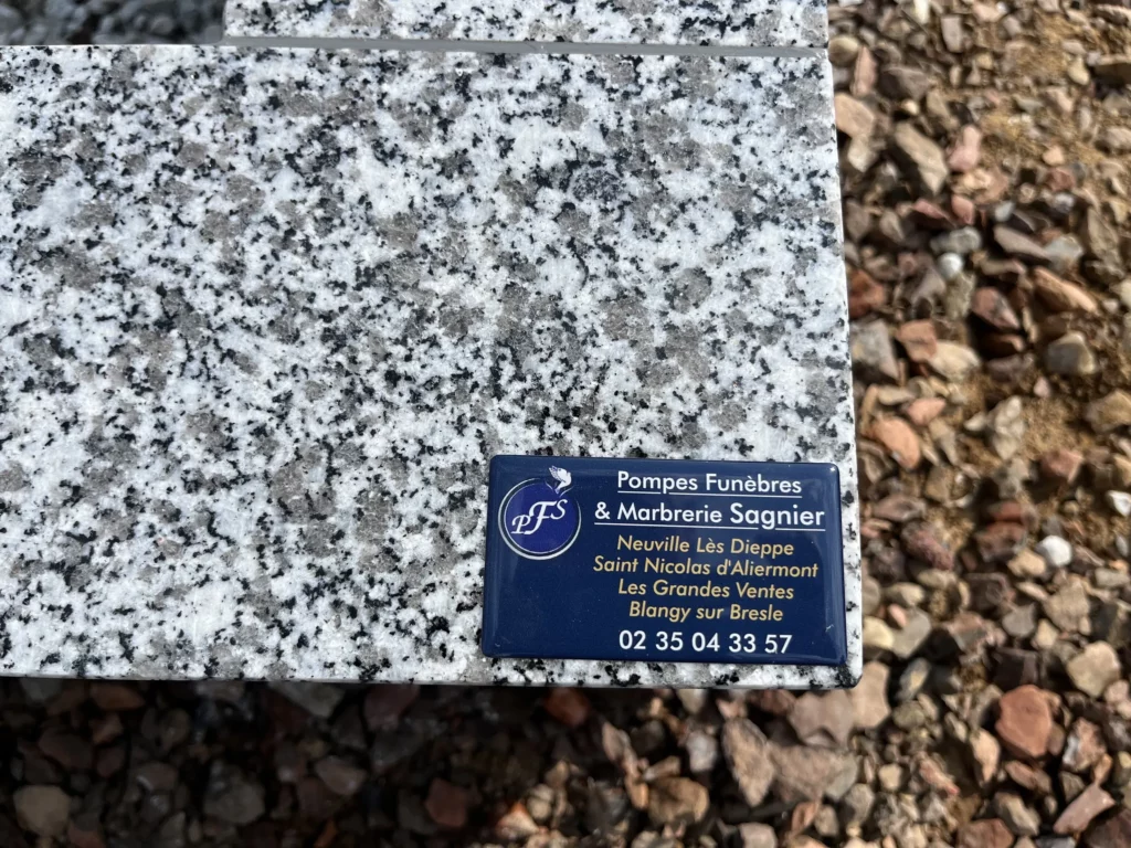 Plaque professionnelle Pompes Funèbres & Marbrerie Sagnier fixée sur du granit.