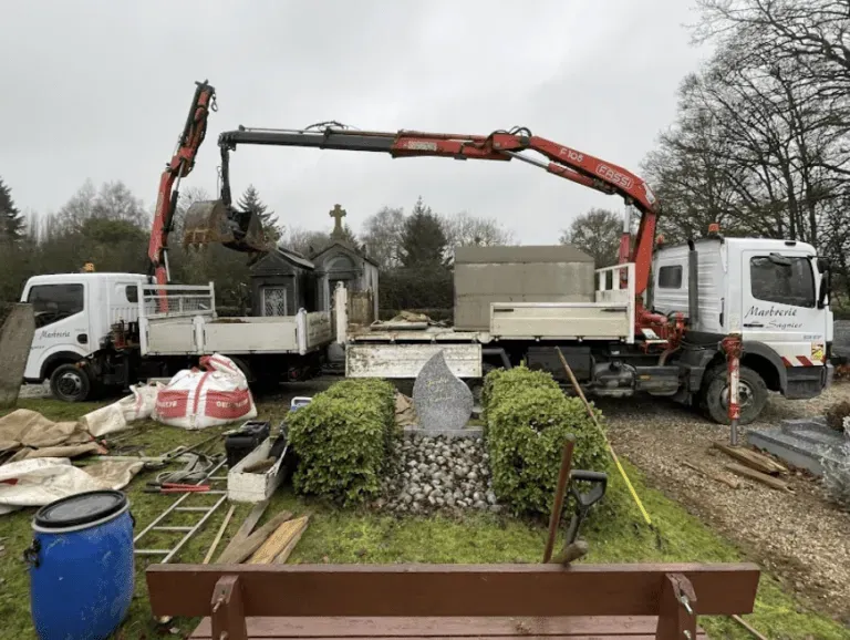 Camions de marbrerie funéraire en intervention de pose dans un cimetière.