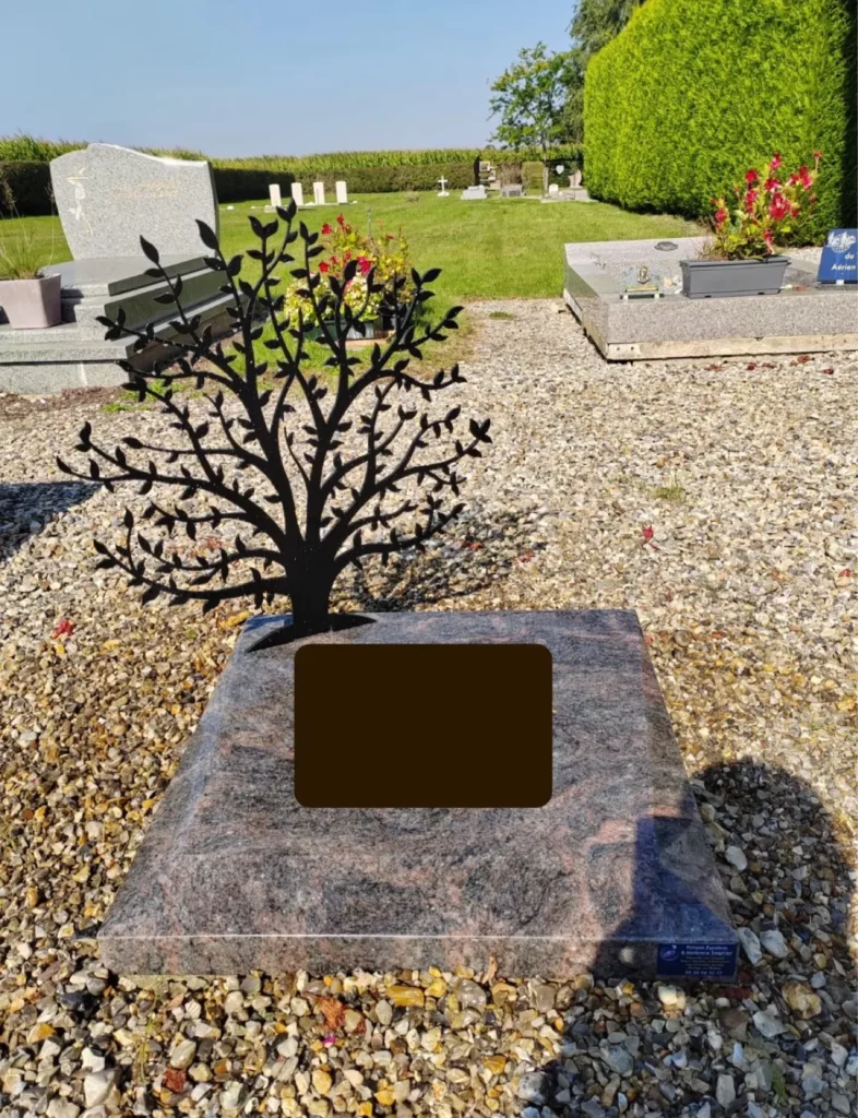 Petit monument funéraire moderne en granit rose agrémenté d'un arbre de vie en métal noir finement découpé.