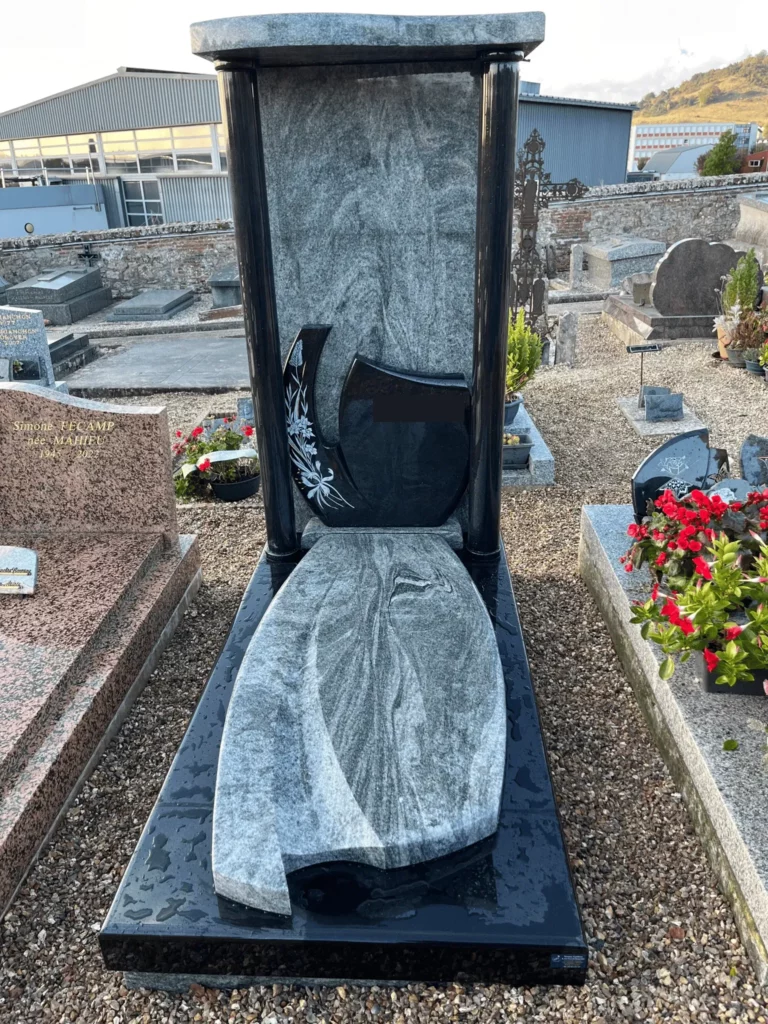 Monument funéraire moderne en granit gris veiné et noir à baldaquin avec stèle sculptée d'un motif floral.