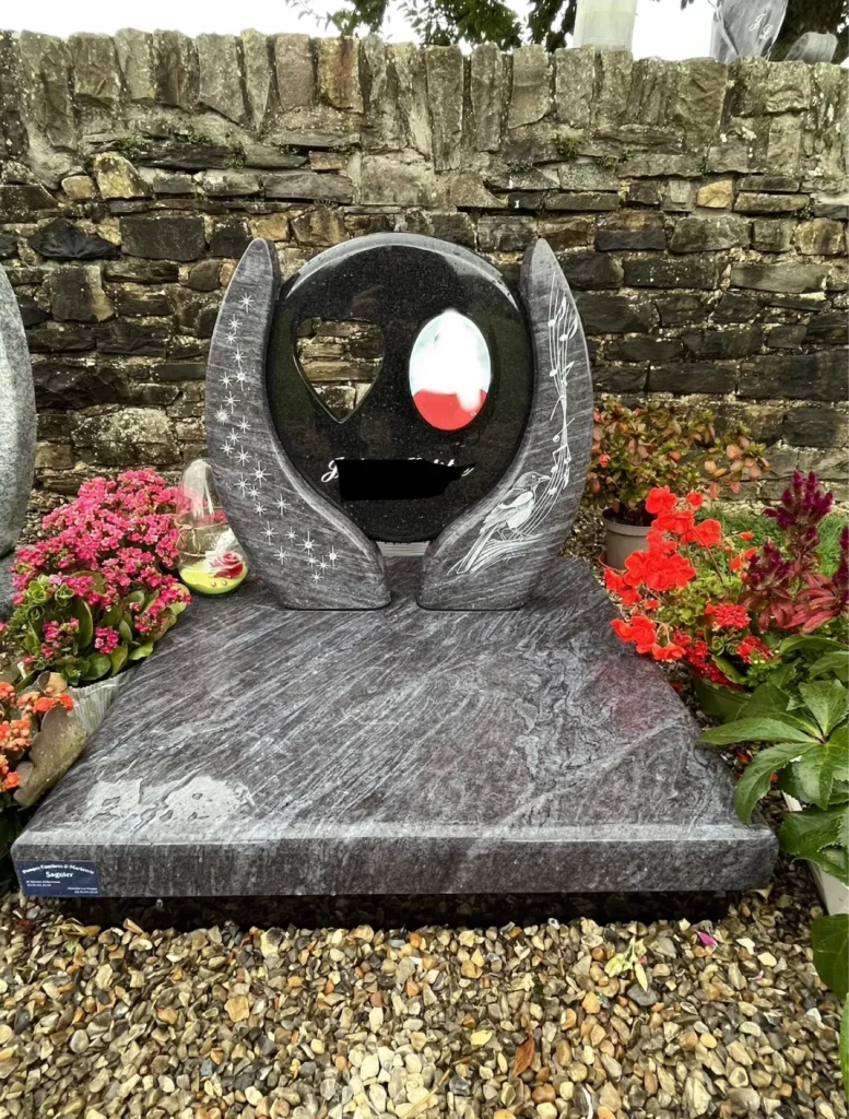 Stèle funéraire originale sculptée avec motif d'oiseau, étoiles et médaillon en granit gris et noir.