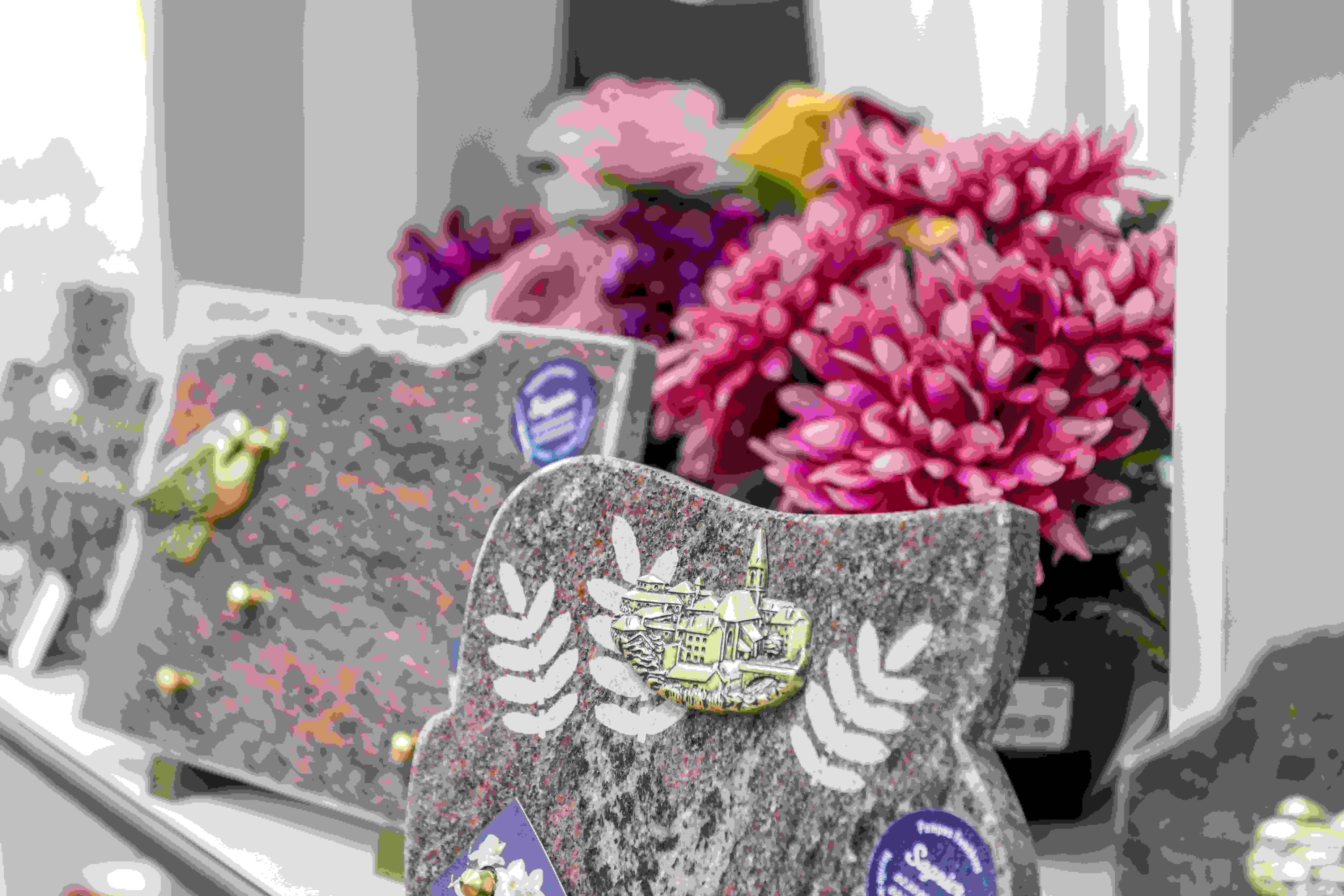 Plaques funéraires en granit personnalisées avec gravures et fleurs artificielles.